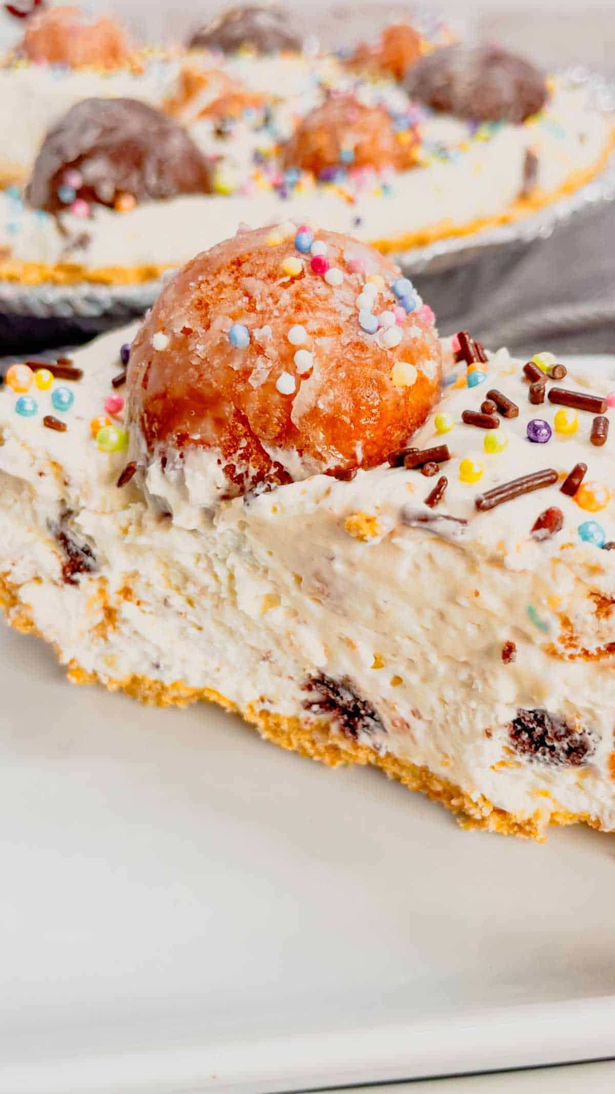 No Bake Timbit Cheesecake is a rich and creamy dessert recipe loaded with tasty donut holes. This cheesecake is made with a store bought graham pie crust and the cream cheese filling is loaded Tim Horton's chocolate and birthday cake flavoured Timbits.