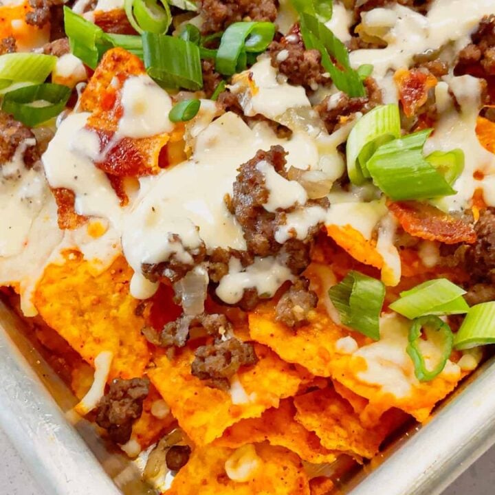 Beef and Bacon Cream Cheese Doritos Nachos are perfect for a fun and easy weeknight dinner or game day snack. These hearty nachos are loaded with seasoned beef, crispy bacon, mozzarella cheese, chopped green onions and drizzled with a rich cream cheese ranch sauce.