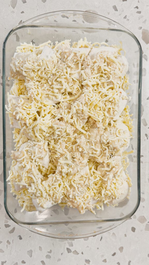shredded mozzarella cheese on top of chicken pierogi casserole before baking