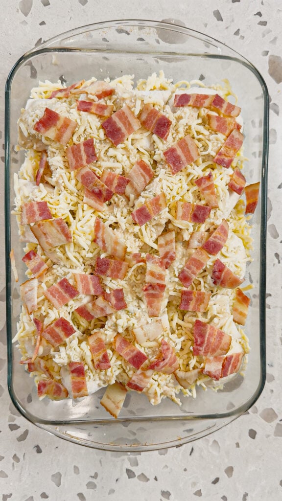 chopped bacon on top of chicken alfredo pierogi casserole before baking