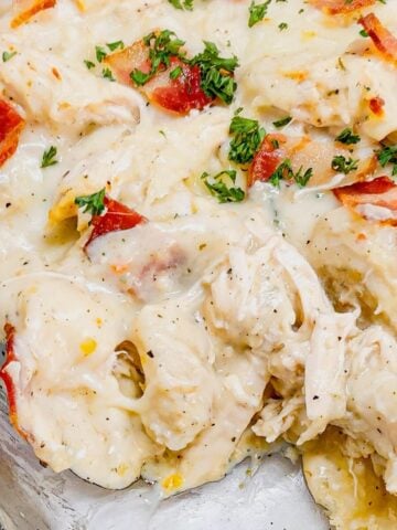 Chicken Alfredo Pierogi Casserole is an easy but hearty dinner recipe that combines two beloved classic foods into one dish. This creamy casserole is loaded with shredded rotisserie chicken, alfredo sauce, pierogies, mozzarella cheese and chopped bacon.