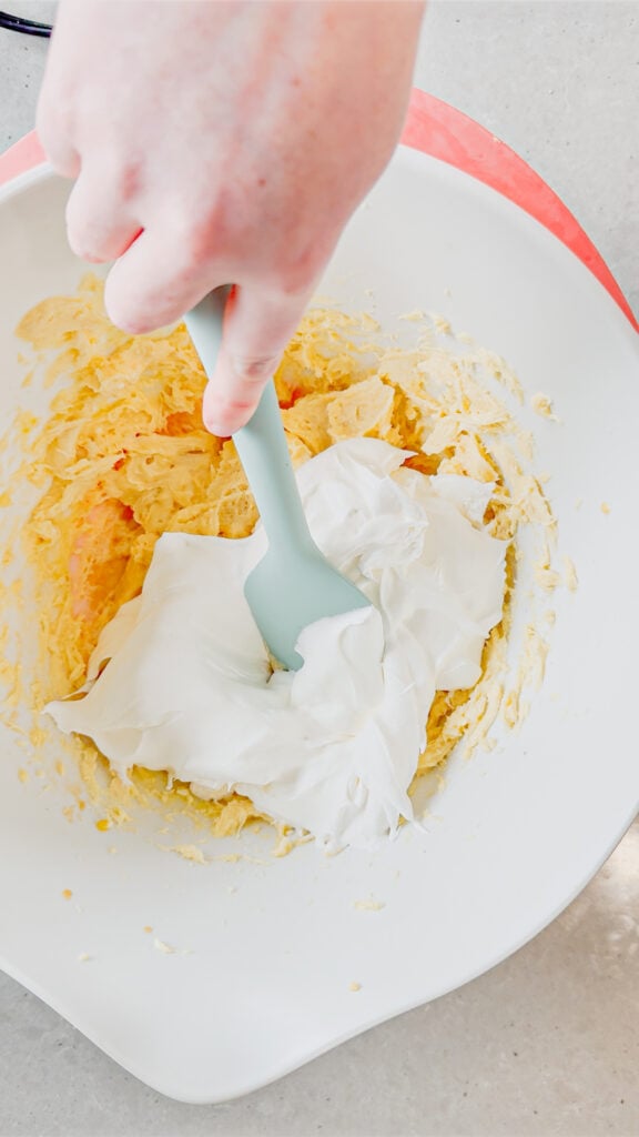cool whip added to mixing bowl with cream cheese and vanilla pudding mixture