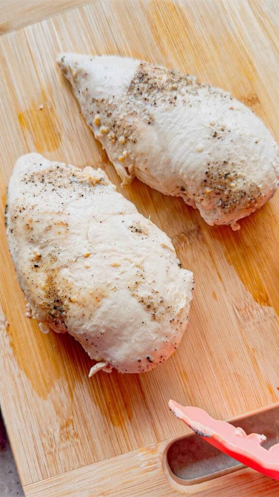 cooked chicken breasts on a cutting board