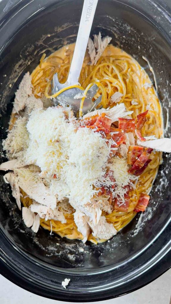 shredded parmesan and chopped cooked bacon added to crock pot with bbq alfredo spaghetti