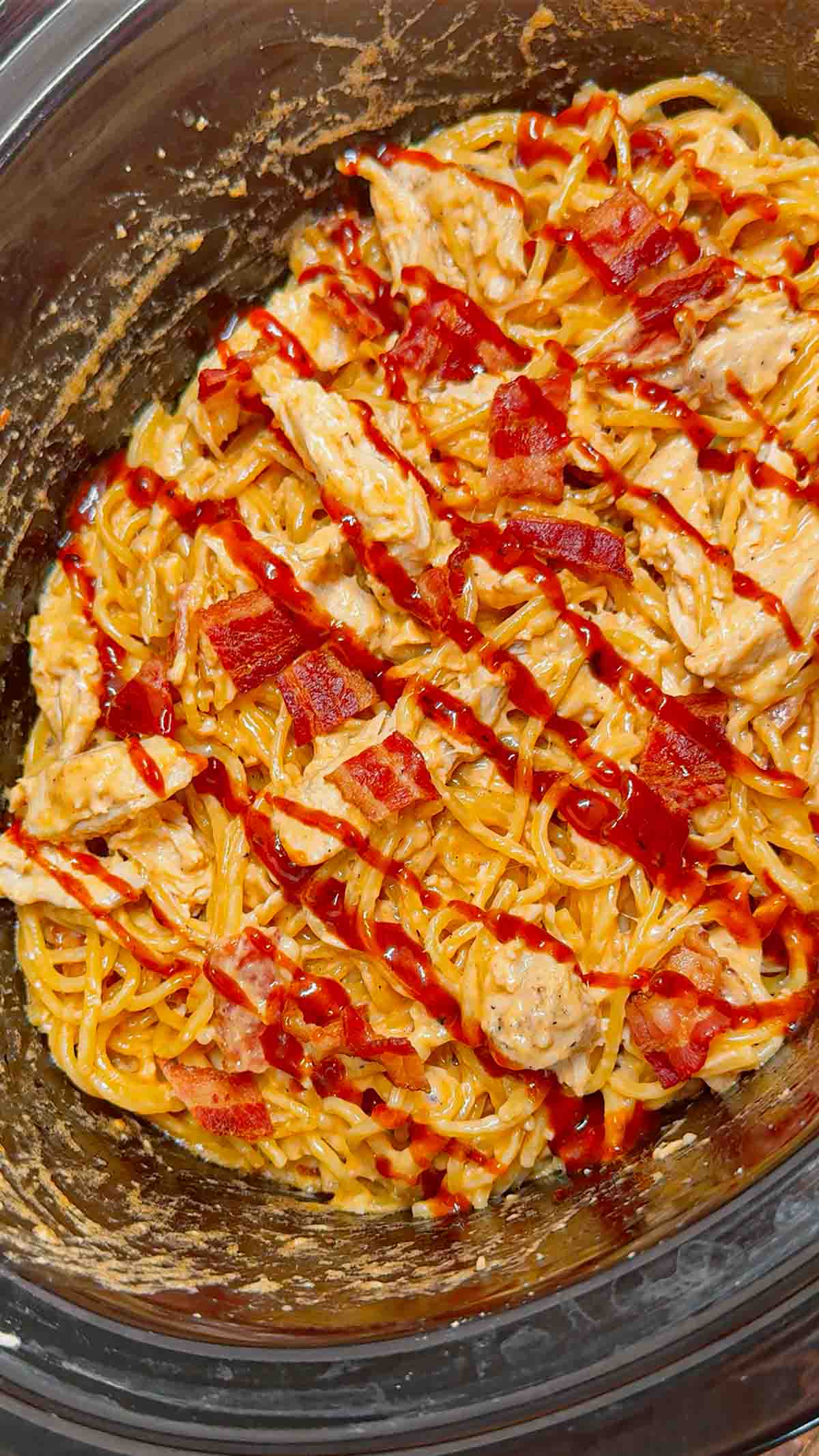Crock Pot BBQ Alfredo Chicken Spaghetti is a flavourful pasta recipe the whole family will love. This slow cooker spaghetti recipe is loaded with chicken breast chunks and chopped bacon and is all tossed in a creamy garlic parmesan alfredo sauce with some barbecue sauce added for a fun flavour twist.