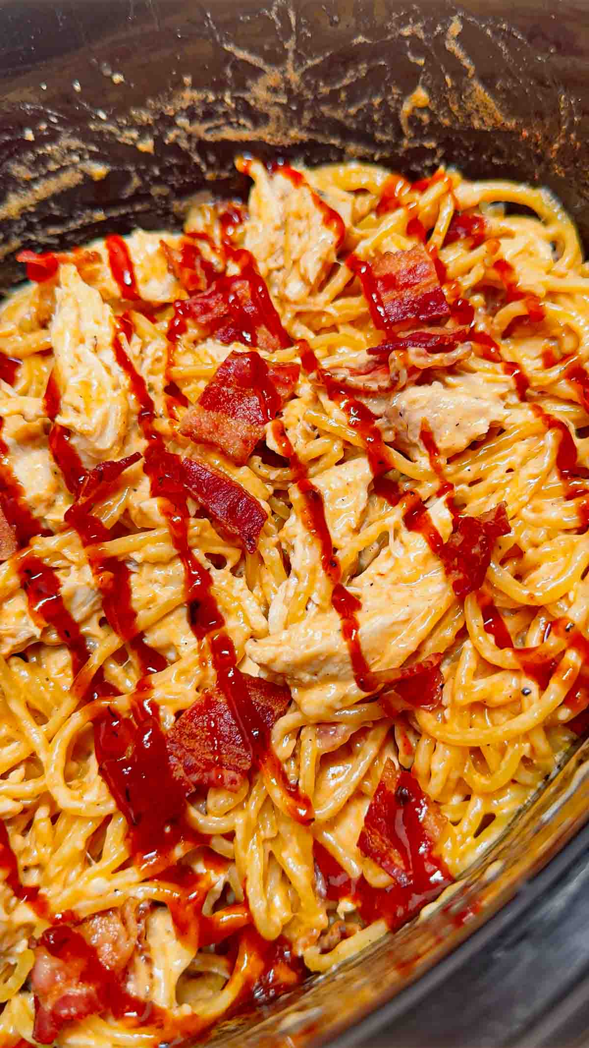 Crock Pot BBQ Alfredo Chicken Spaghetti is a flavourful pasta recipe the whole family will love. This slow cooker spaghetti recipe is loaded with chicken breast chunks and chopped bacon and is all tossed in a creamy garlic parmesan alfredo sauce with some barbecue sauce added for a fun flavour twist.