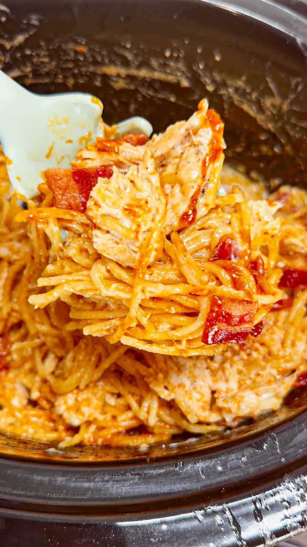 Crock Pot BBQ Alfredo Chicken Spaghetti is a flavourful pasta recipe the whole family will love. This slow cooker spaghetti recipe is loaded with chicken breast chunks and chopped bacon and is all tossed in a creamy garlic parmesan alfredo sauce with some barbecue sauce added for a fun flavour twist.