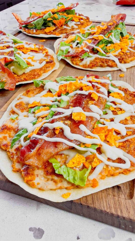 Doritos Crusted Chicken Smash Tacos are a fun twist on smash burger tacos. Flour tortillas are spread with a ground chicken and crushed Doritos mixture and fried until crispy before being topped with shredded mozzarella, chopped lettuce, crispy bacon, ranch dressing and more Doritos.