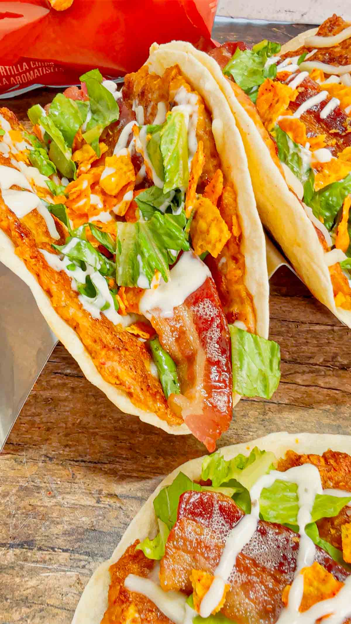 Doritos Crusted Chicken Smash Tacos are a fun twist on smash burger tacos. Flour tortillas are spread with a ground chicken and crushed Doritos mixture and fried until crispy before being topped with shredded mozzarella, chopped lettuce, crispy bacon, ranch dressing and more Doritos.
