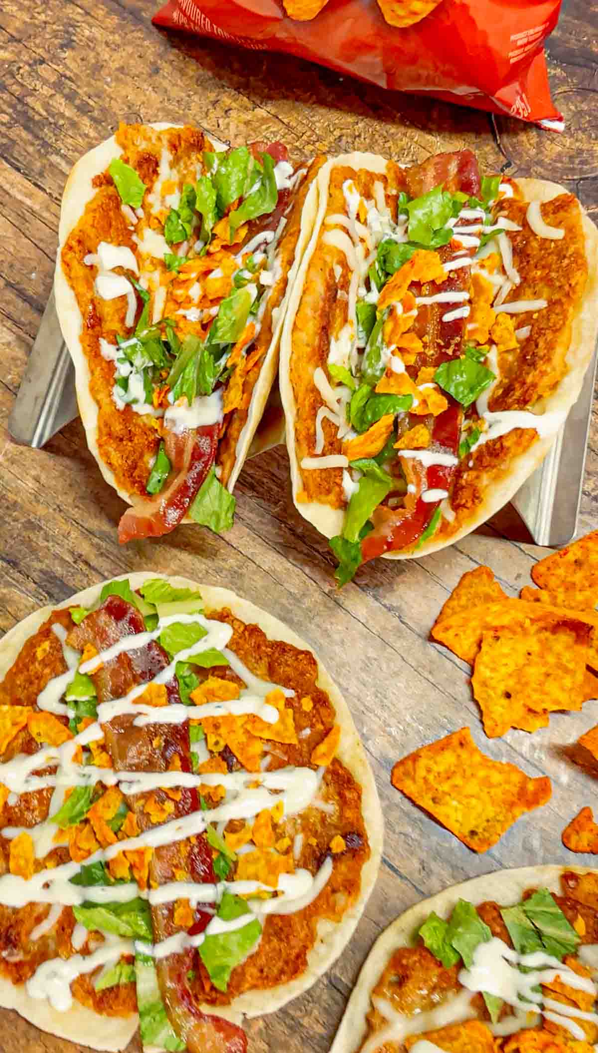 Doritos Crusted Chicken Smash Tacos are a fun twist on smash burger tacos. Flour tortillas are spread with a ground chicken and crushed Doritos mixture and fried until crispy before being topped with shredded mozzarella, chopped lettuce, crispy bacon, ranch dressing and more Doritos.