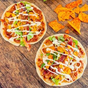 Doritos Crusted Chicken Smash Tacos are a fun twist on smash burger tacos. Flour tortillas are spread with a ground chicken and crushed Doritos mixture and fried until crispy before being topped with shredded mozzarella, chopped lettuce, crispy bacon, ranch dressing and more Doritos.