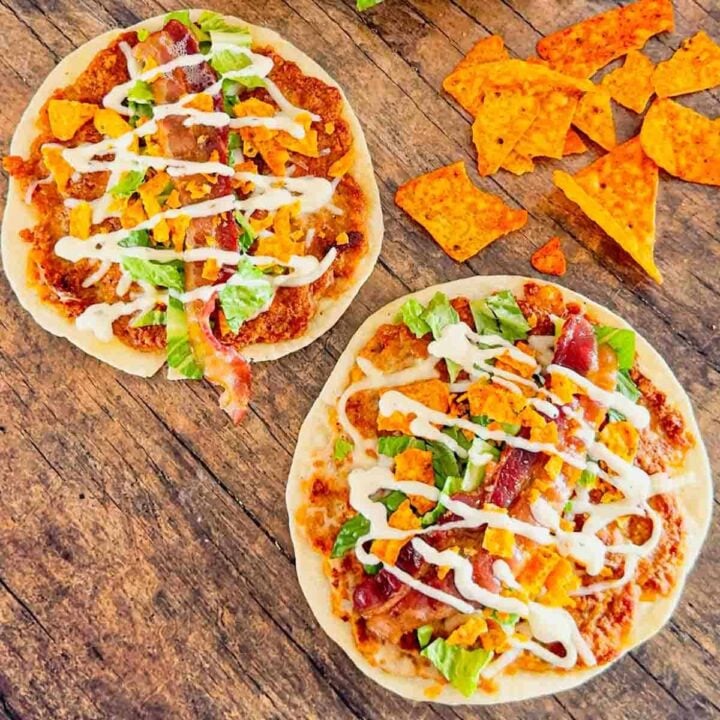 Doritos Crusted Chicken Smash Tacos are a fun twist on smash burger tacos. Flour tortillas are spread with a ground chicken and crushed Doritos mixture and fried until crispy before being topped with shredded mozzarella, chopped lettuce, crispy bacon, ranch dressing and more Doritos.