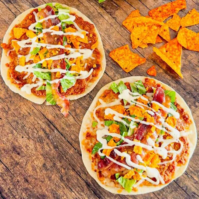 Doritos Crusted Chicken Smash Tacos are a fun twist on smash burger tacos. Flour tortillas are spread with a ground chicken and crushed Doritos mixture and fried until crispy before being topped with shredded mozzarella, chopped lettuce, crispy bacon, ranch dressing and more Doritos.