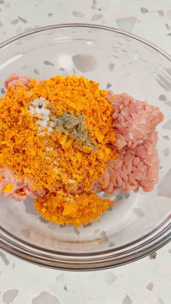 salt, pepper, crushed doritos and ground chicken in a mixing bowl