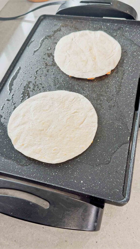 chicken smash tacos cooking on the griddle meat side down