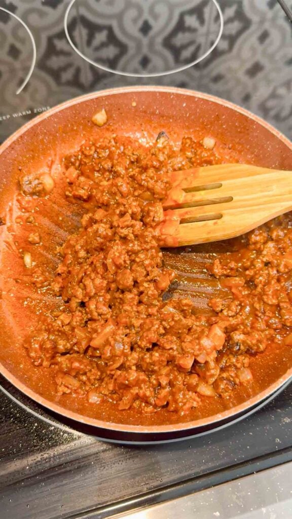 sloppy joe ground beef mixture being stirred in a skillet