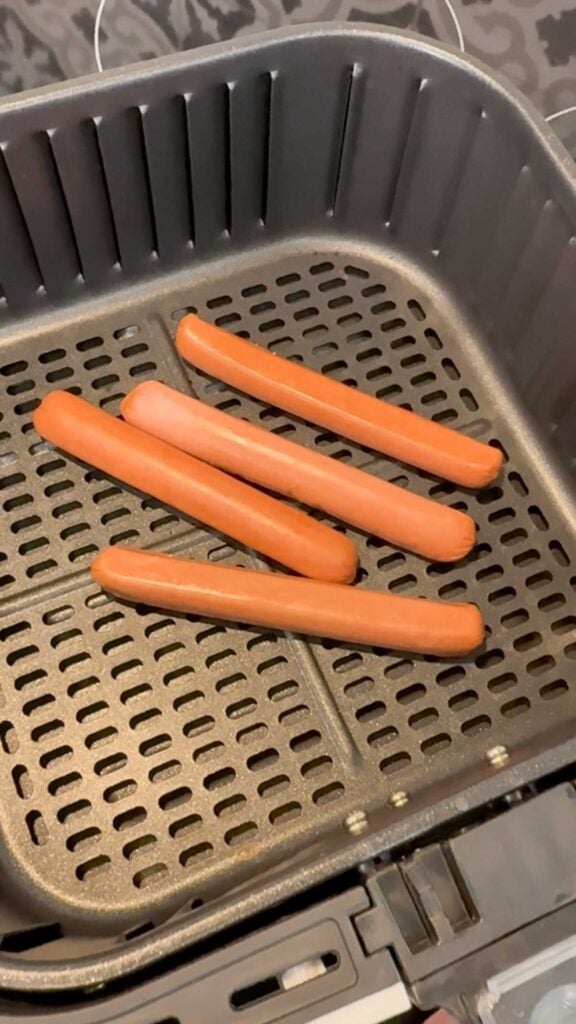hot dog wieners in an air fryer basket