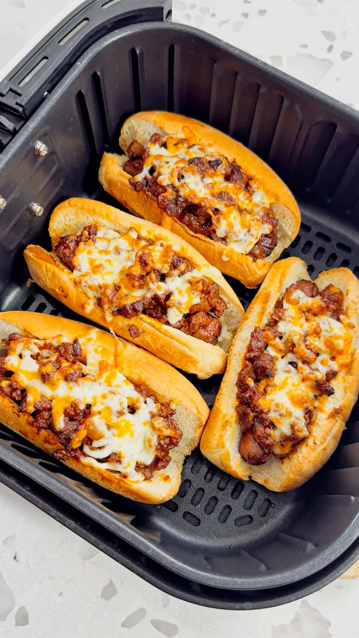Air Fryer Sloppy Joe Dogs are a fun and easy recipe perfect for lunches or weeknight dinners. These tasty hot dogs are loaded with a homemade ground beef sloppy joe mixture and shredded cheese and air fried until perfectly toasted.