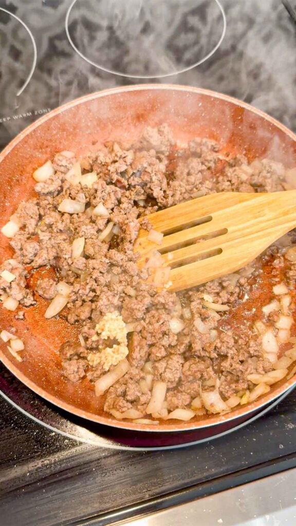 minced garlic added to skillet with cooked ground beef