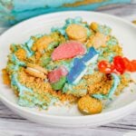 Summer Dirt Cake is an easy no bake dessert recipe perfect for parties and potlucks. This beach themed dirt cake is made with golden Oreo and graham cracker crumbs, layered with a delicious cream cheese and vanilla pudding mixture and all topped with mini cookies and beach themed gummy candies.