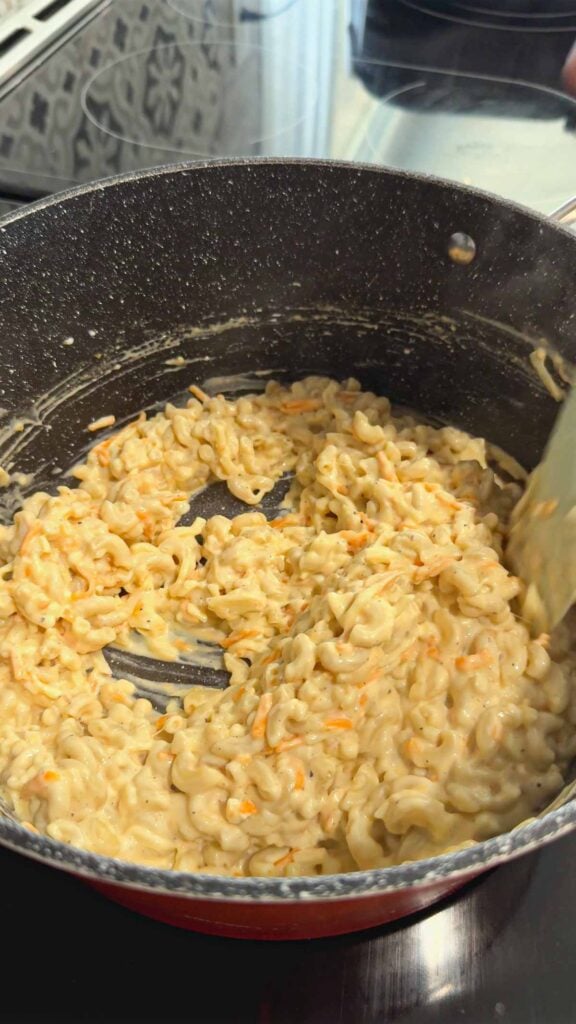 stirring mac and cheese in a pot