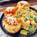 Dino Nugget Chicken Parm Cups are a fun and easy muffin tin dinner the whole family will love. Hamburger buns are spread with garlic butter, baked in muffin tins and stuffed with creamy alfredo spaghetti and topped with dino nuggets, marinara and mozzarella.