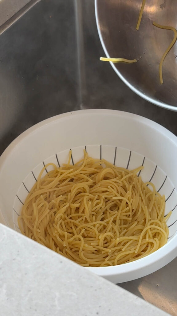 cooked spaghetti in a strainer