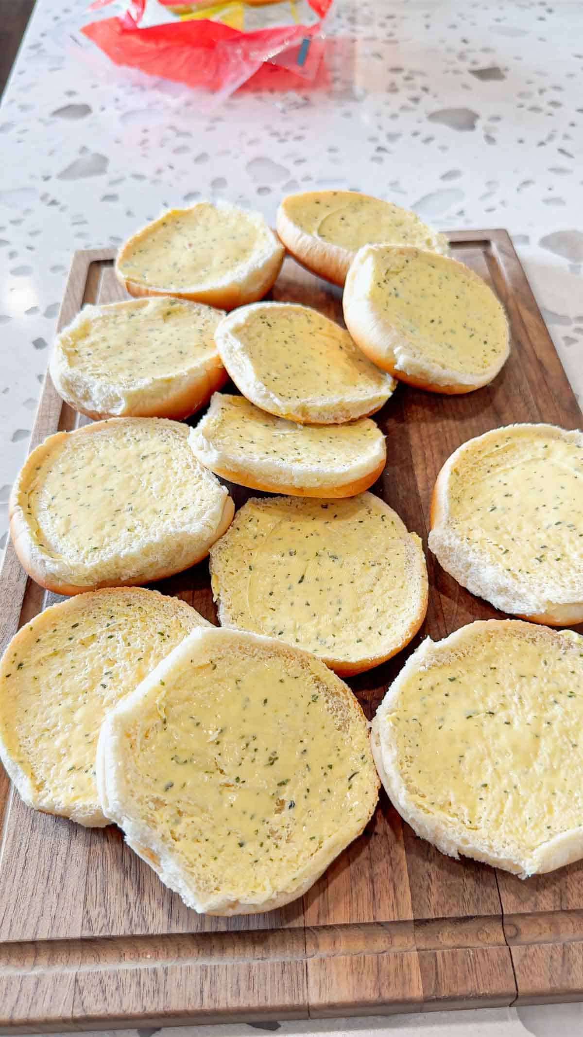 split hamburger buns spread with garlic butter