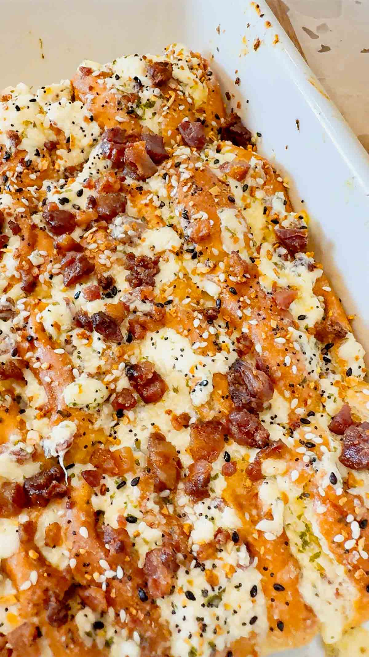 Everything Bacon Cheesy Hawaiian Roll Garlic Bread is the perfect party food or dinner side dish. King's Hawaiian Rolls are sliced and stuffed with herb and garlic cream cheese, crumbled bacon and shredded mozzarella cheese, brushed with garlic butter and topped with everything bagel seasoning before being baked to melty perfection.
