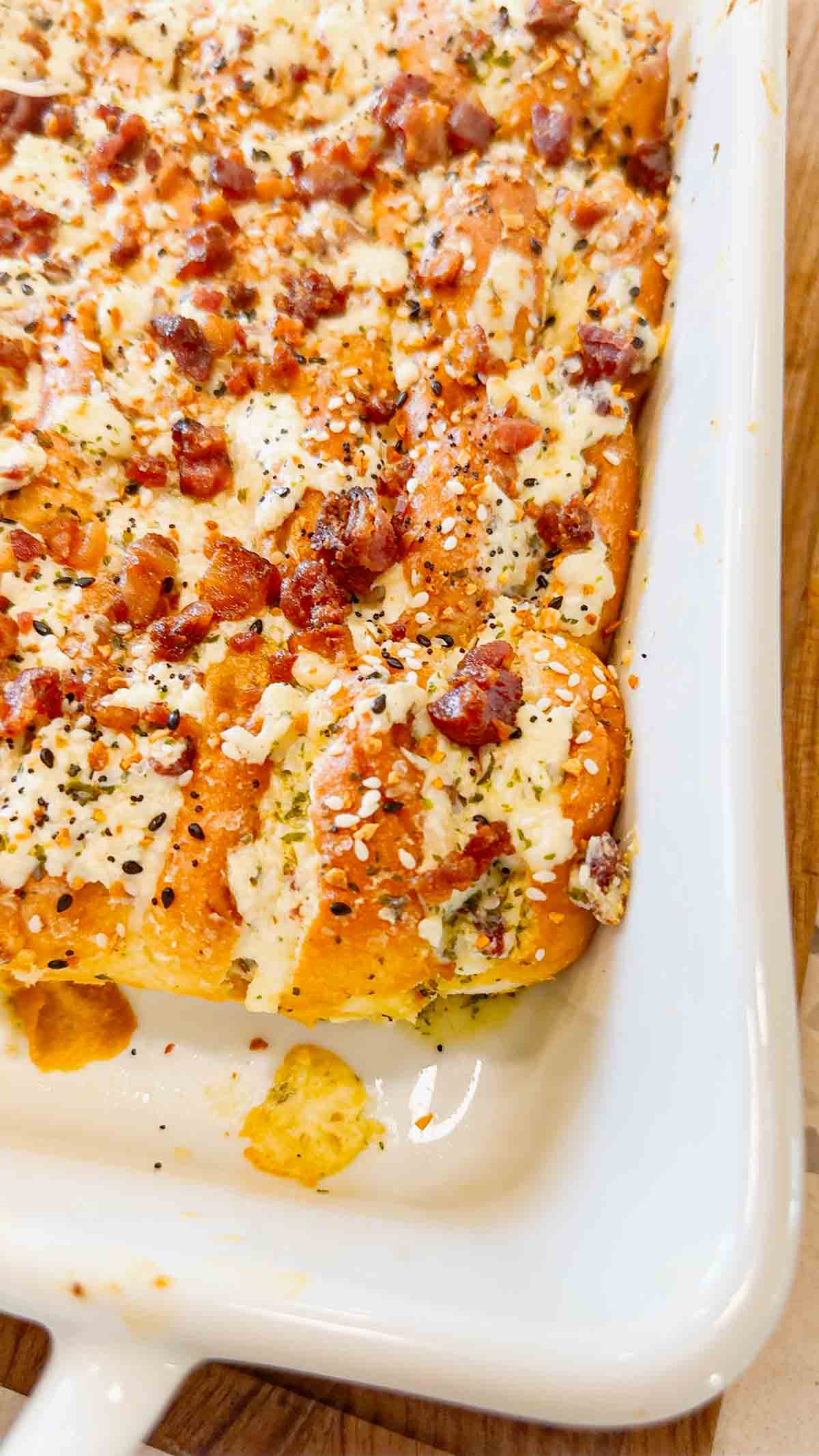 Everything Bacon Cheesy Hawaiian Roll Garlic Bread is the perfect party food or dinner side dish. King's Hawaiian Rolls are sliced and stuffed with herb and garlic cream cheese, crumbled bacon and shredded mozzarella cheese, brushed with garlic butter and topped with everything bagel seasoning before being baked to melty perfection.