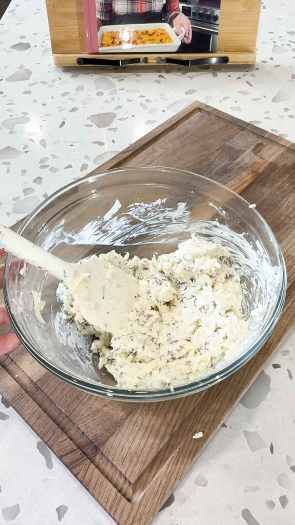 cream cheese, shredded mozzarella and bacon crumble mixture in glass mixing bowl