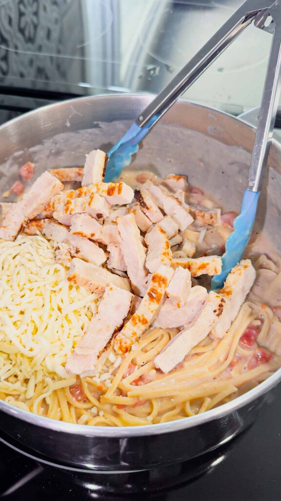 grilled chicken strips and shredded mozzarella cheese added to pot with linguine alfredo