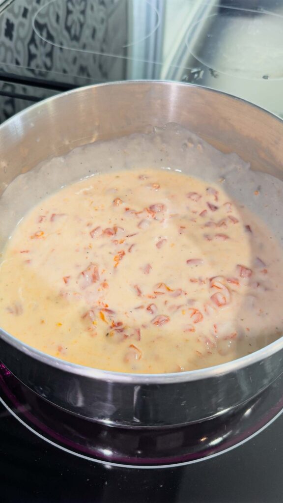 rotel and alfredo sauce stirred together in a pot
