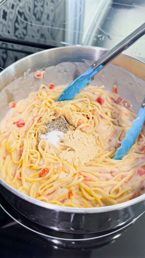 salt, pepper and garlic powder added to pot with linguine alfredo
