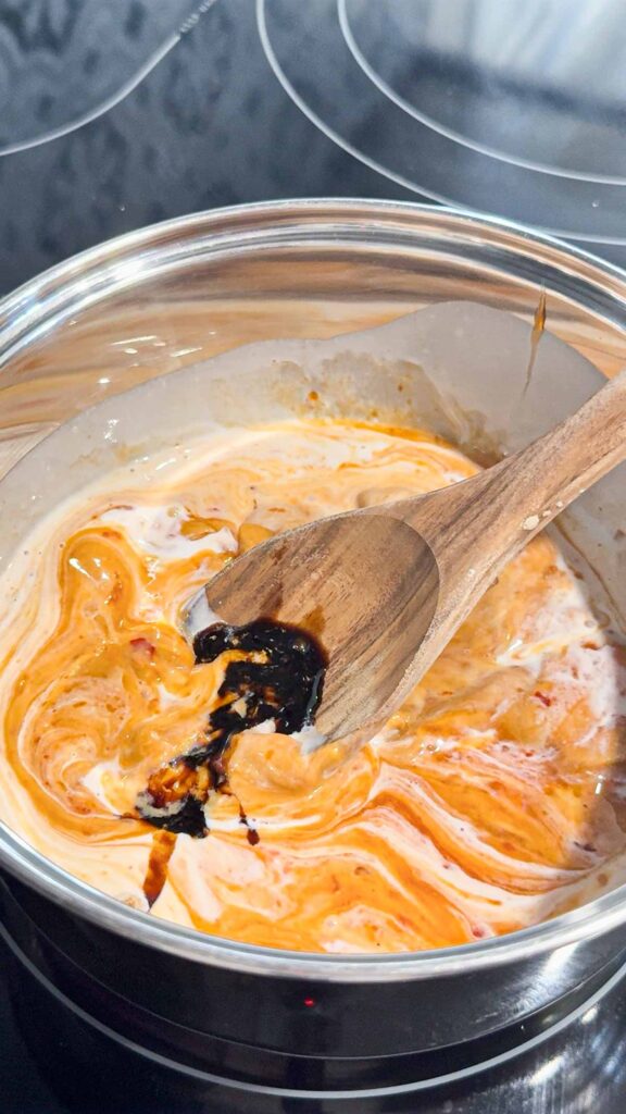 soy sauce added to pot with coconut milk, peanut butter and sweet chili Thai sauce mixture