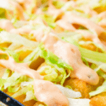 Big Mac Tater Tot Casserole is an easy weeknight dinner recipe idea that is super kid friendly. This ground beef and potato casserole has all the flavours of you favourite fast food sandwich. It starts with a base of ground beef, diced onions and dill pickles and is topped with cheese, tater tots, lettuce and copycat big mac sauce.