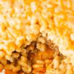 Mac and Cheese Meatloaf Casserole is a fun mashup of two classic comfort food meals. This fun dinner idea starts with a ground beef meatloaf base topped with a ketchup meatloaf glaze followed by a top layer of creamy macaroni and cheese. This is a family friendly dinner recipe the kids will love.