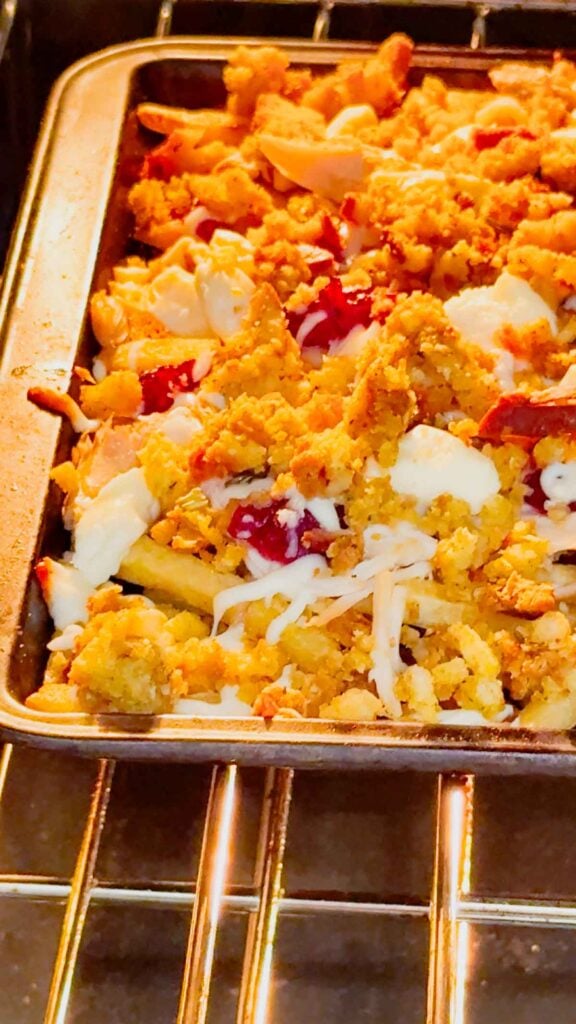 sheet pan thanksgiving poutine baking in the oven