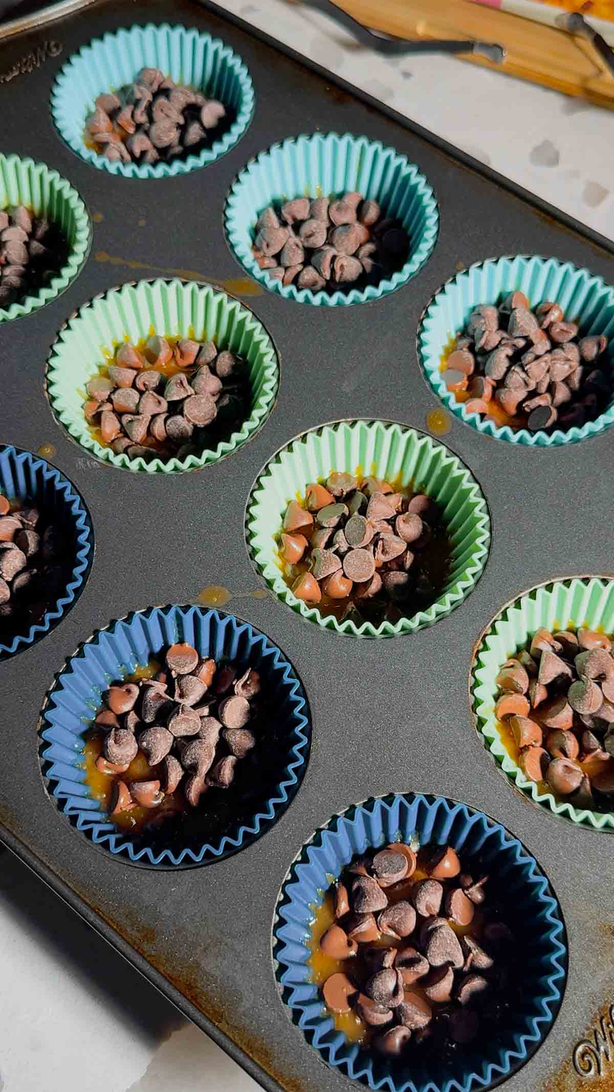 semi sweet chocolate chips on top of ritz cracker toffee in muffin cups