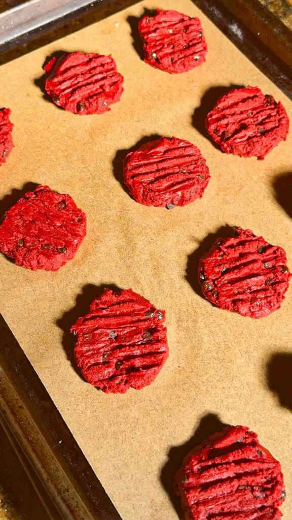 flattened red velvet shortbread cookie dough on a baking sheet