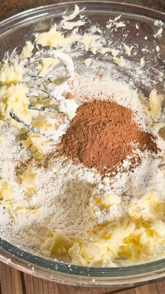 cocoa powder, flour and cornstarch added to mixing bowl with creamed butter mixture