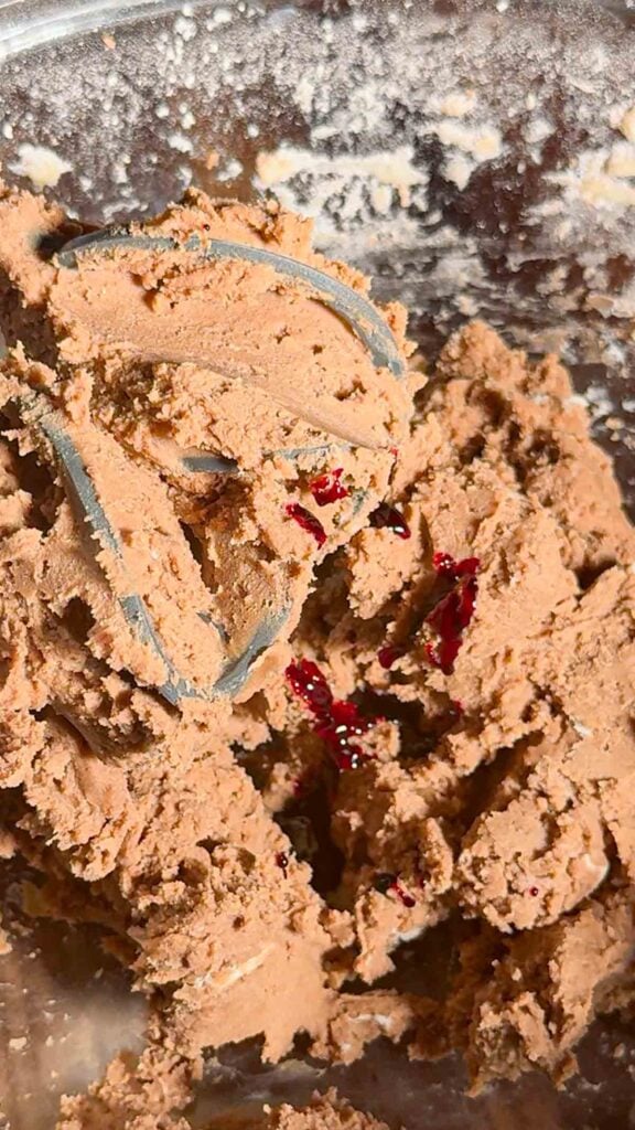 red food colouring added to mixing bowl with shortbread cookie dough