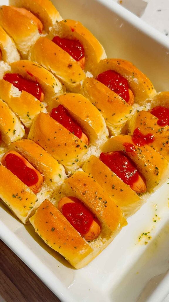 pizza sauce spread on cocktail wieners in a Hawaiian rolls