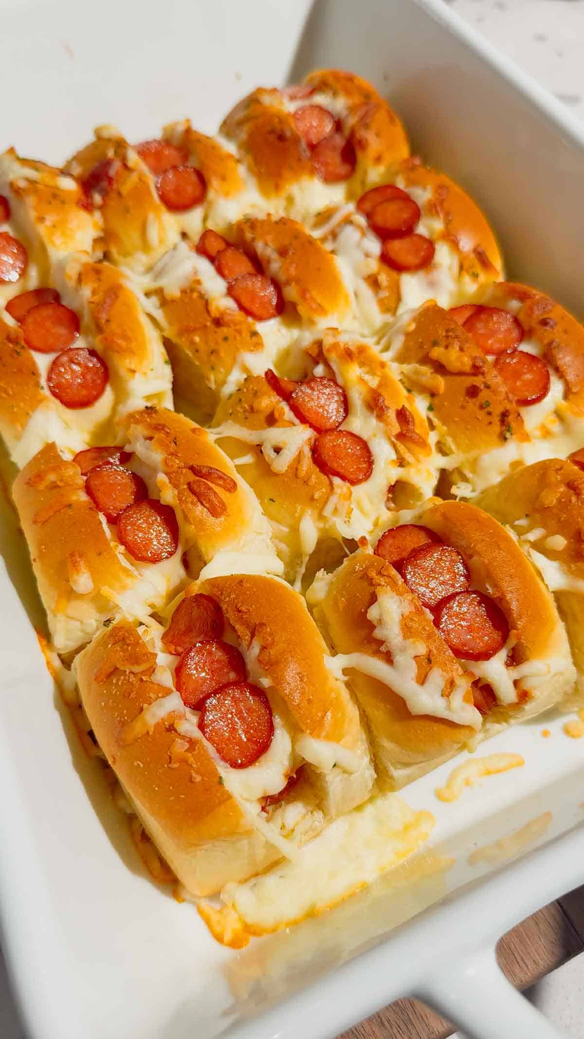 Craving fun, bite-sized party food? These Mini Pizza Dog Sliders are the ultimate crowd-pleaser! King's Hawaiian rolls brushed with garlic butter, stuffed with cocktail wieners, topped with tangy pizza sauce, heaps of shredded mozzarella & mini pepperoni slices—baked 18 minutes at 350°F until golden, toasty & bubbly! Ready in 30 minutes total (12 min prep), makes 12 mini hot dog sliders. Perfect game day snack, kid-friendly appetizer, easy party food, Super Bowl treat or quick family dinner. So cheesy, so fun! 🍕🌭🥖 #MiniPizzaDogs #PizzaDogSliders #CocktailWeinerSliders #KingHawaiianRecipes #EasyAppetizers #GameDayFood #PartyFoodIdeas #MiniHotDogs #CheesySliders #QuickSnacks #KidFriendlyRecipes #BakedSliders
