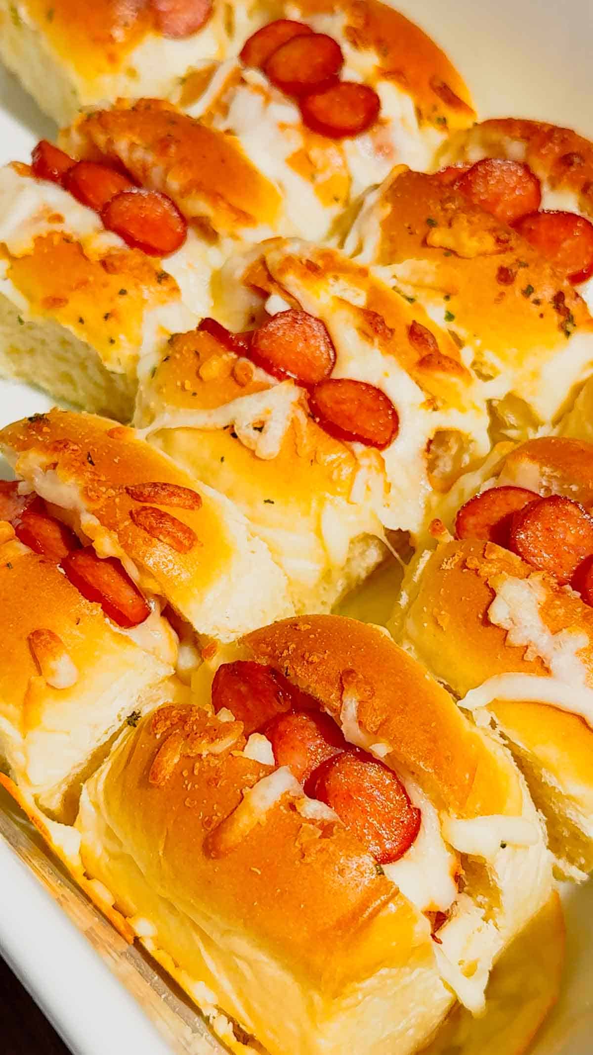 Craving fun, bite-sized party food? These Mini Pizza Dog Sliders are the ultimate crowd-pleaser! King's Hawaiian rolls brushed with garlic butter, stuffed with cocktail wieners, topped with tangy pizza sauce, heaps of shredded mozzarella & mini pepperoni slices—baked 18 minutes at 350°F until golden, toasty & bubbly! Ready in 30 minutes total (12 min prep), makes 12 mini hot dog sliders. Perfect game day snack, kid-friendly appetizer, easy party food, Super Bowl treat or quick family dinner. So cheesy, so fun! 🍕🌭🥖 #MiniPizzaDogs #PizzaDogSliders #CocktailWeinerSliders #KingHawaiianRecipes #EasyAppetizers #GameDayFood #PartyFoodIdeas #MiniHotDogs #CheesySliders #QuickSnacks #KidFriendlyRecipes #BakedSliders