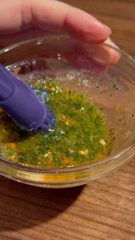 stirring butter, garlic powder and parsley flakes together in a small glass bowl