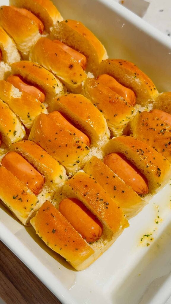 cocktail wieners in Hawaiian rolls in a baking dish