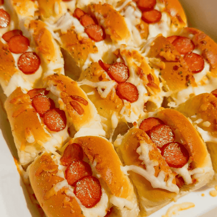 Craving fun, bite-sized party food? These Mini Pizza Dog Sliders are the ultimate crowd-pleaser! King's Hawaiian rolls brushed with garlic butter, stuffed with cocktail wieners, topped with tangy pizza sauce, heaps of shredded mozzarella & mini pepperoni slices—baked 18 minutes at 350°F until golden, toasty & bubbly! Ready in 30 minutes total (12 min prep), makes 12 mini hot dog sliders. Perfect game day snack, kid-friendly appetizer, easy party food, Super Bowl treat or quick family dinner. So cheesy, so fun! 🍕🌭🥖 #MiniPizzaDogs #PizzaDogSliders #CocktailWeinerSliders #KingHawaiianRecipes #EasyAppetizers #GameDayFood #PartyFoodIdeas #MiniHotDogs #CheesySliders #QuickSnacks #KidFriendlyRecipes #BakedSliders