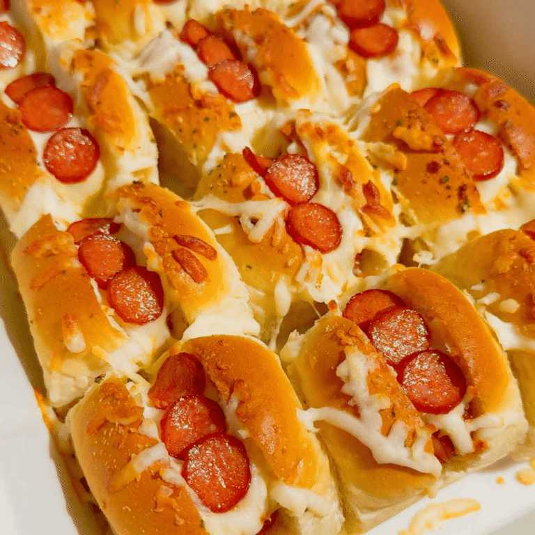 Craving fun, bite-sized party food? These Mini Pizza Dog Sliders are the ultimate crowd-pleaser! King's Hawaiian rolls brushed with garlic butter, stuffed with cocktail wieners, topped with tangy pizza sauce, heaps of shredded mozzarella & mini pepperoni slices—baked 18 minutes at 350°F until golden, toasty & bubbly! Ready in 30 minutes total (12 min prep), makes 12 mini hot dog sliders. Perfect game day snack, kid-friendly appetizer, easy party food, Super Bowl treat or quick family dinner. So cheesy, so fun! 🍕🌭🥖 #MiniPizzaDogs #PizzaDogSliders #CocktailWeinerSliders #KingHawaiianRecipes #EasyAppetizers #GameDayFood #PartyFoodIdeas #MiniHotDogs #CheesySliders #QuickSnacks #KidFriendlyRecipes #BakedSliders