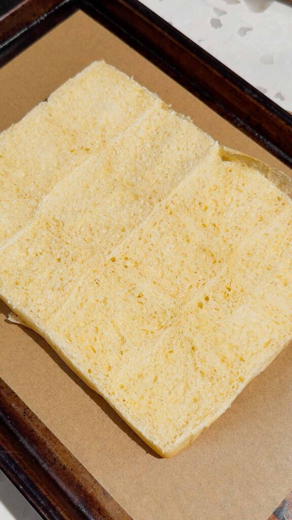 kings hawaiian rolls sliced open and the bottoms placed on a baking sheet